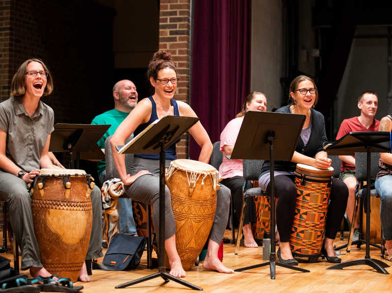 Musicians performing with drums on stage.